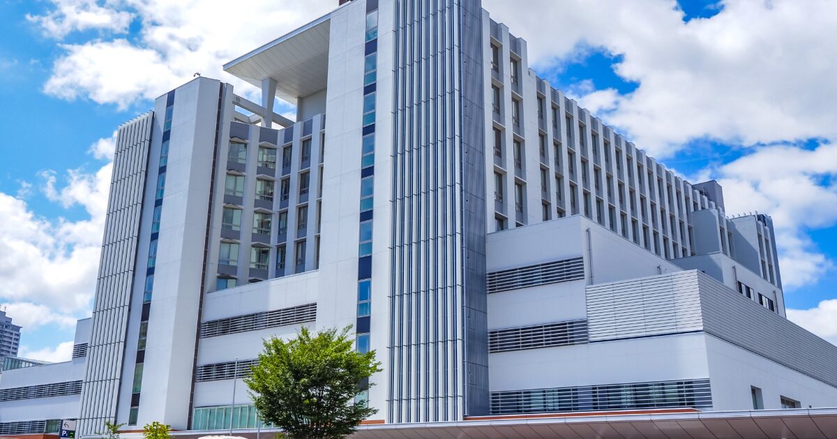 東北大学病院の近代的な白い外観と晴れた空